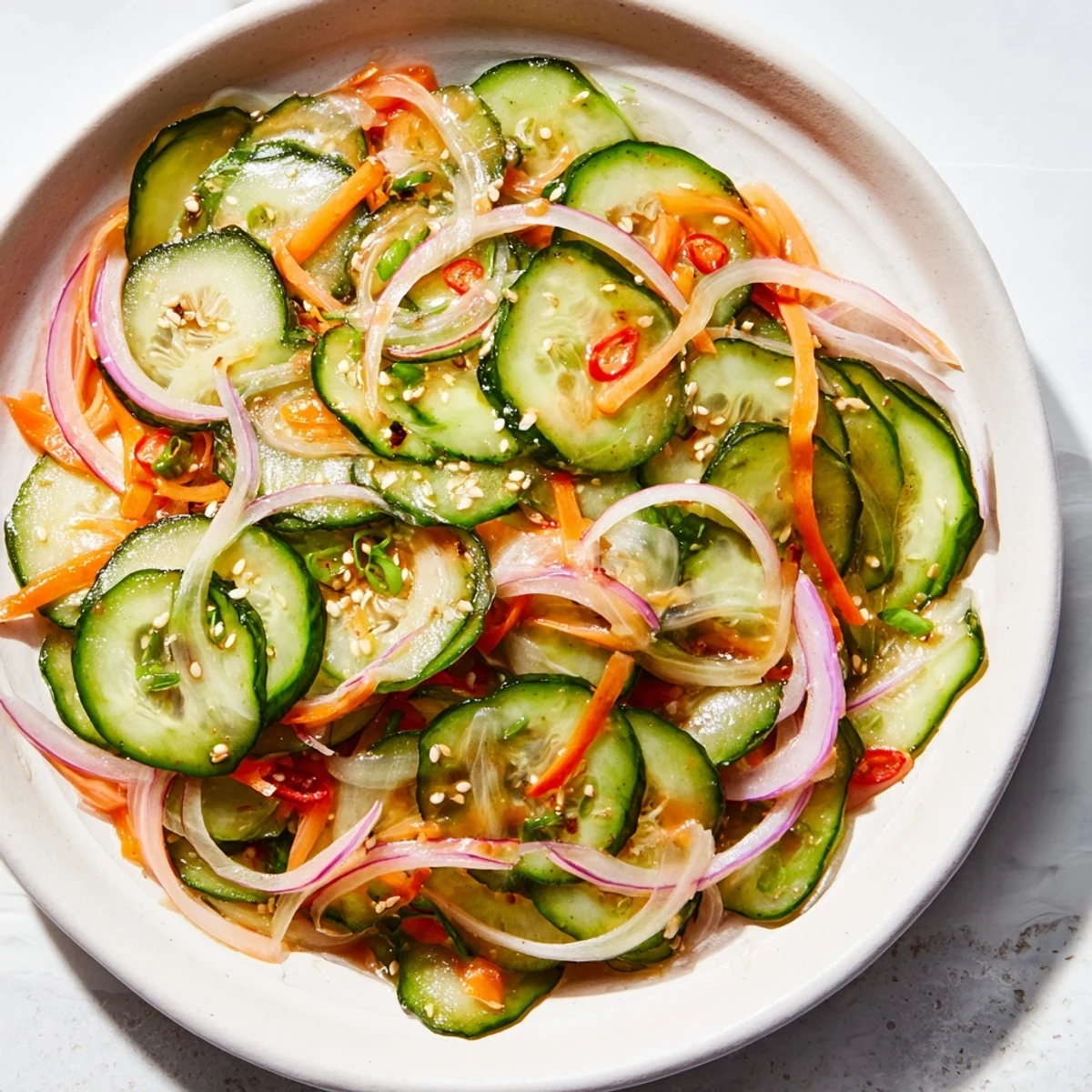 Vibrant cucumber salad remix adorned with sesame seeds and fresh veggies.  