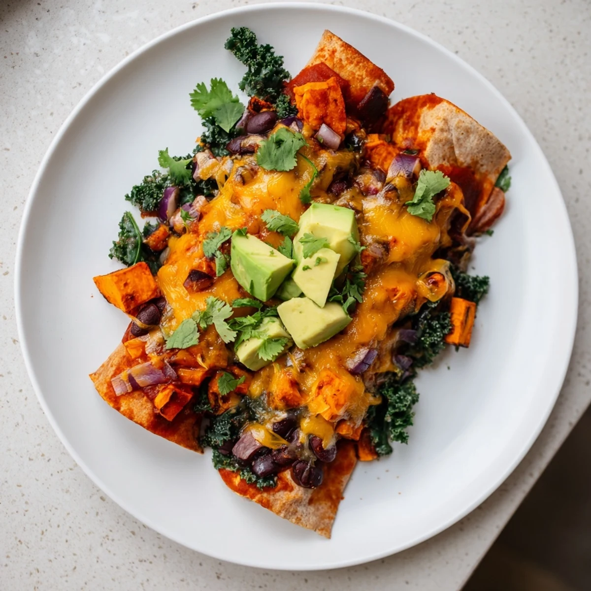 Smoky aromas of roasted veggies infuse these one-pan sweet potato, black bean & kale enchiladas, topped with melted cheese.