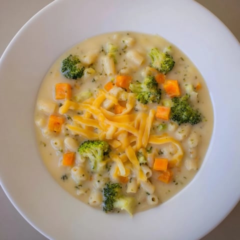 Steaming bowl of One-Pot Broccoli Cheddar Ditalini Soup, a hearty, cheesy American classic.