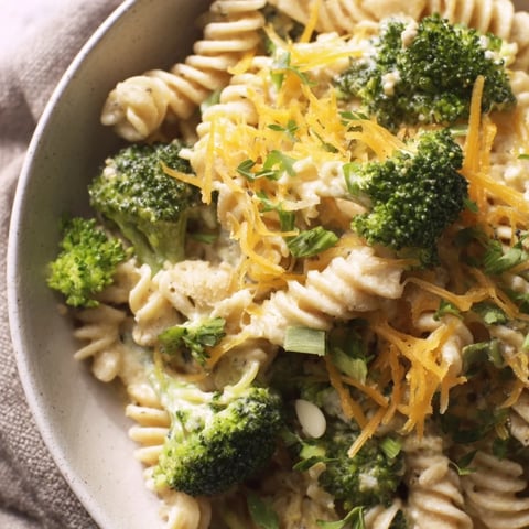 Creamy Green Goddess Broccoli Cheddar One-Pot Pasta with vibrant herbs and melted cheddar, ready to serve.