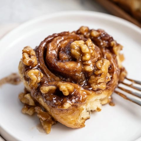 Close-up of gooey Cinnamon Maple Walnut Sticky Buns with crunchy walnuts; perfect brunch.