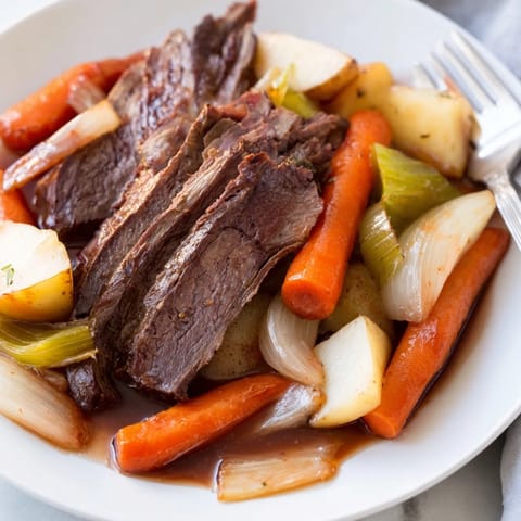Hearty Sunday pot roast surrounded by vibrant roasted vegetables, a comforting delight.  