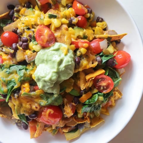 A steaming skillet of Veggie-Packed Taco Skillet with Avocado Yogurt, brimming with colorful vegetables.