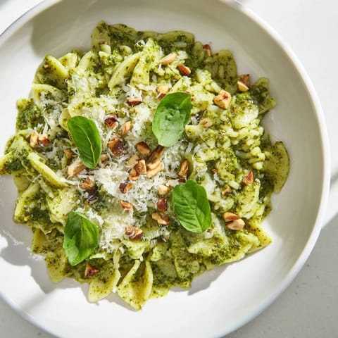 A vibrant close-up depicts the finished 15-Minute Creamy Pesto Risoni with a swirl of rich pesto sauce.