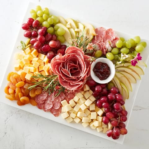 A bountiful Holiday Bow Appetizer Platter showcasing a delicious arrangement of cheese, meats, and colorful garnishes.
