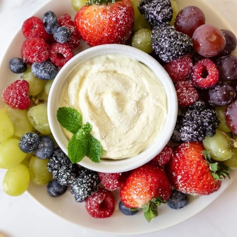 A beautifully arranged Mistletoe Kiss Berry Dip Board showcases colorful fruit alongside a creamy central dip for sharing.