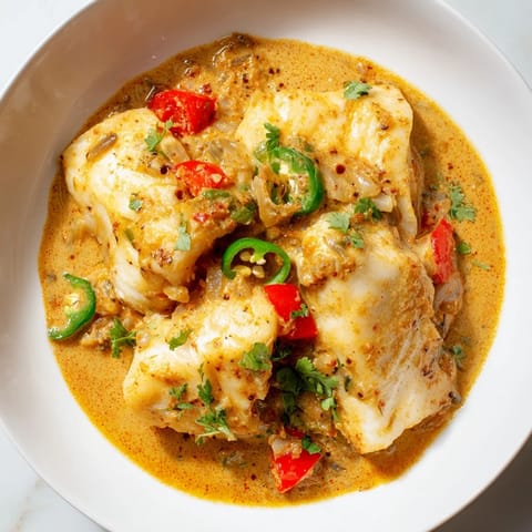 Fragrant Bahraini Fish Curry simmering gently, showcasing the tender white fish in rich, flavorful sauce.