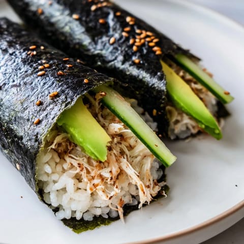 Close-up of a delicious plate of Sushi Rice Hand Rolls with creamy avocado and shredded crab.