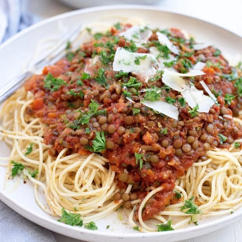 Hearty vegan Lentil Bolognese simmering in a pot, showcasing tender lentils and tomatoes for a comforting Italian dinner.  
